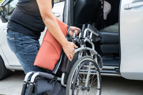 A wheelchair user is seated in front of a truck, showcasing the integration of wheelchair and ambulatory transportation solutions.