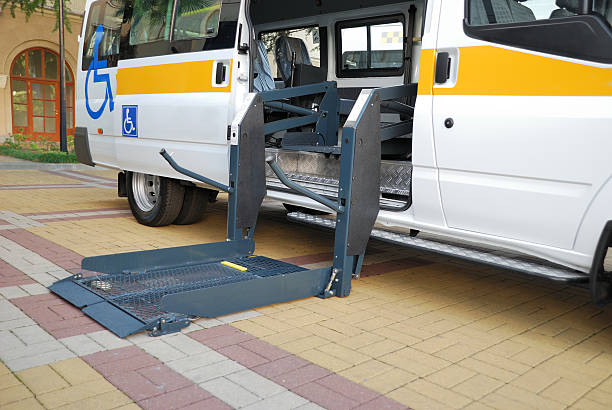  A white van with yellow and blue stripes, serving as private medical transportation, parked on the side of the road.